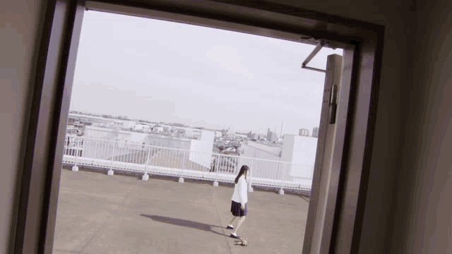 a person standing on a rooftop with a view of the city