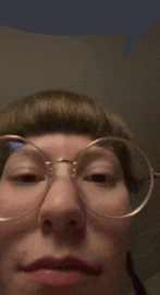 a close up of a person wearing glasses making a funny face