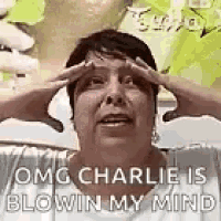 a woman is making a funny face with her hands on her forehead .