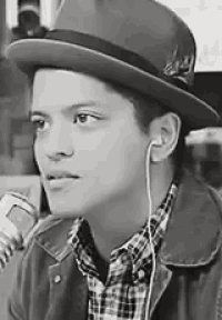 a black and white photo of a young man wearing a hat and earphones .