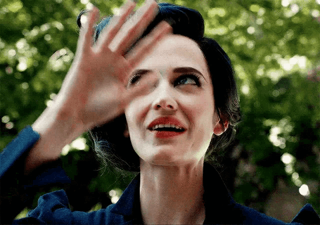 a close up of a woman covering her eyes with her hand