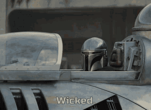 a man in a helmet sits in the cockpit of a vehicle with the word wicked written on the bottom