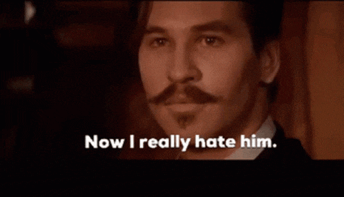 a man with a mustache and beard says now i really hate him