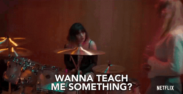 a woman is playing drums and a man is playing guitar .