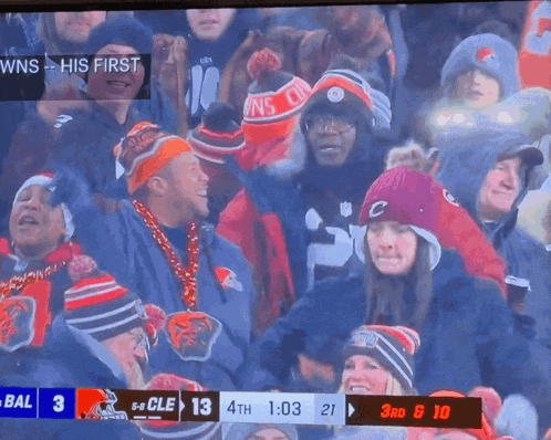 a crowd of people are watching a football game and the score is 5-5 cle