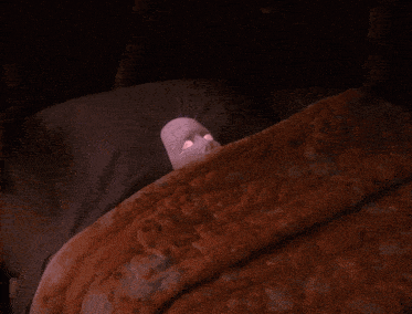 a person with a mask on their face is laying in bed