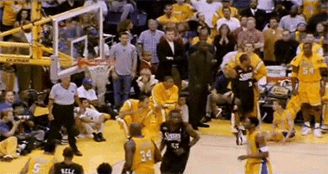 a basketball game is being played in front of a crowd . the players are wearing jerseys with the number 34 on them .