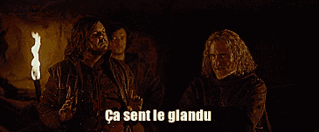 a group of men are standing next to each other with the caption " ca sent le glandu "
