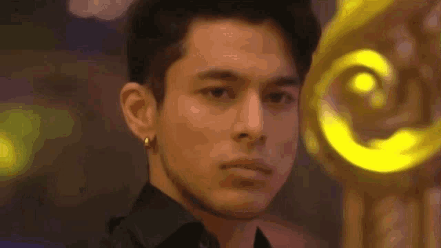 a close up of a man 's face with a yellow light behind him .