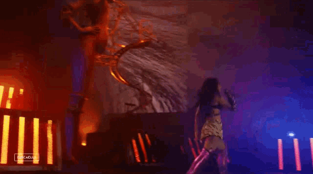 a woman is singing into a microphone on a stage in front of a staircase .