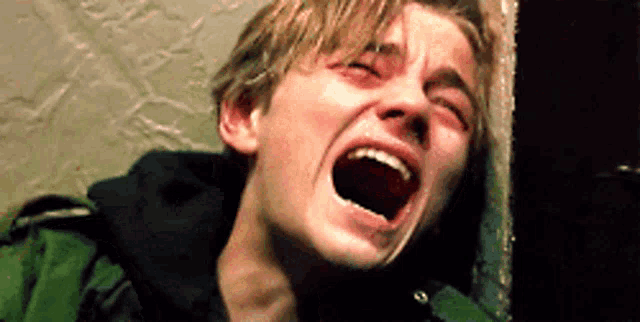 a young man is screaming with his mouth open .