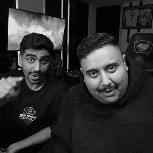 a black and white photo of two men one wearing a shirt which says extreme motorsport
