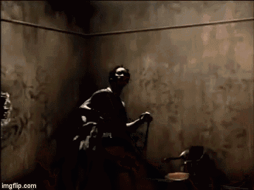 a man is standing in a dark room holding a cane