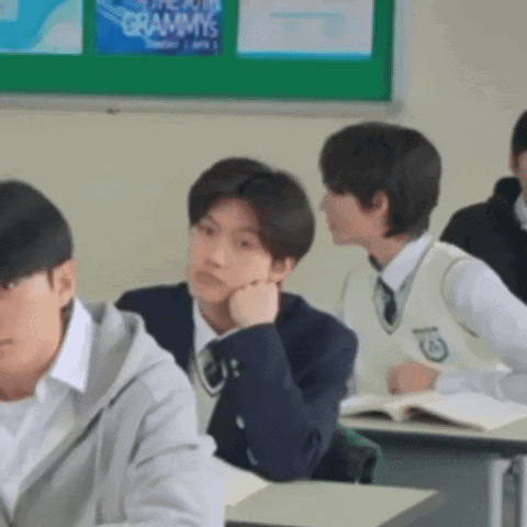 a group of students are sitting at desks in a classroom with a sign that says grammys on it