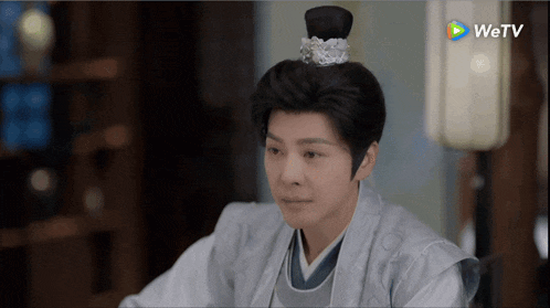 a man with a crown on his head is sitting in front of a wetv logo