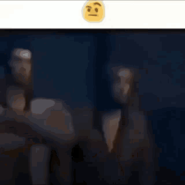a blurry picture of two men standing next to each other with a smiley face above them .