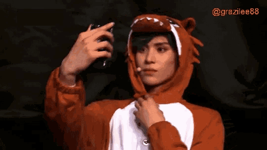 a man in a dinosaur costume is taking a selfie with his phone