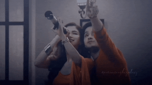 a man and a woman are looking through a telescope together .