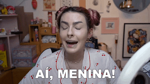 a woman with red hair and a nose ring says ai menina