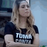 a woman is wearing a black t-shirt that says toma conta .
