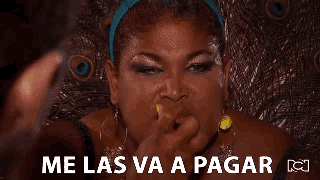 a woman with a peacock feather behind her says me las va a pagar in spanish
