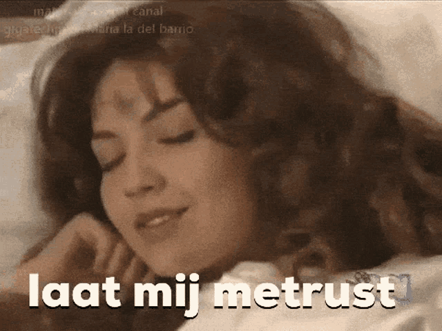 a woman is laying in bed with the words laat mij metrust written on her face