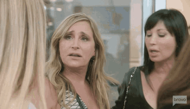 a group of women are talking and one of them is wearing a shirt that says bravo on it