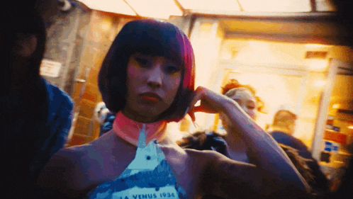 a woman with pink hair is wearing a dress that says venus 1934