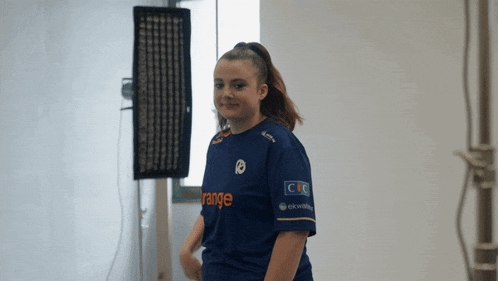 a girl wearing a blue shirt that says range on it