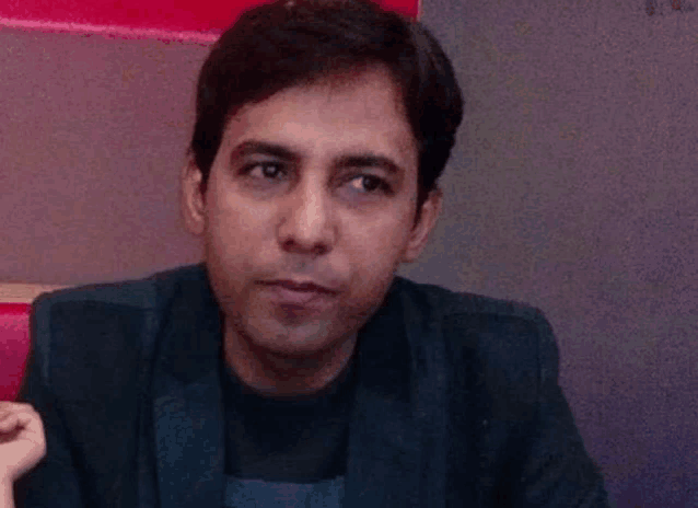 a man in a suit is looking at the camera with a red background