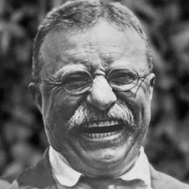 a man with glasses and a mustache laughs with his mouth open