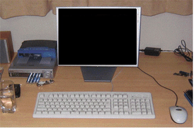 a computer monitor sits on a desk next to a keyboard
