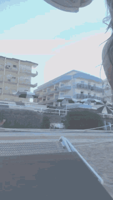 a person is sitting on a beach chair with a hotel in the background
