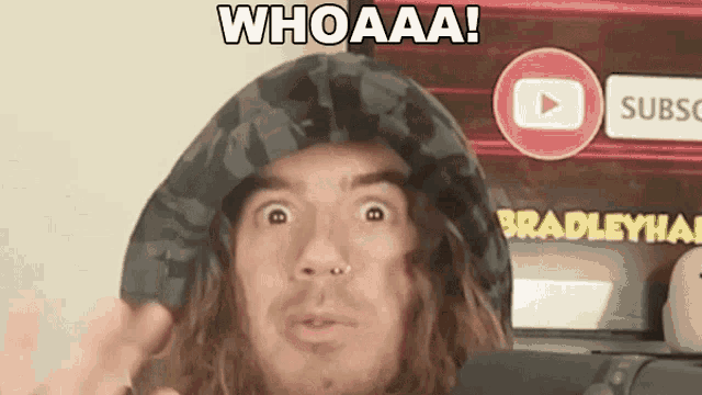 a man with long hair is wearing a hooded jacket and says whoaaa