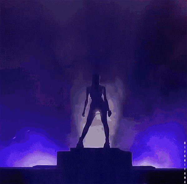 a silhouette of a woman standing on a stage