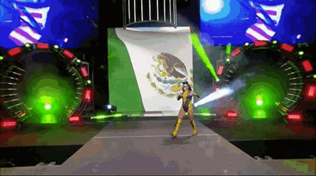a woman is walking down a runway in front of a mexican flag