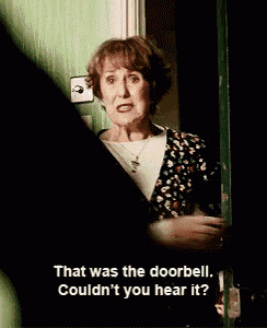 a woman is standing in front of a door and says that was the doorbell couldn t you hear it ?