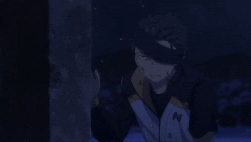 a man with the letter n on his jacket is standing in the dark