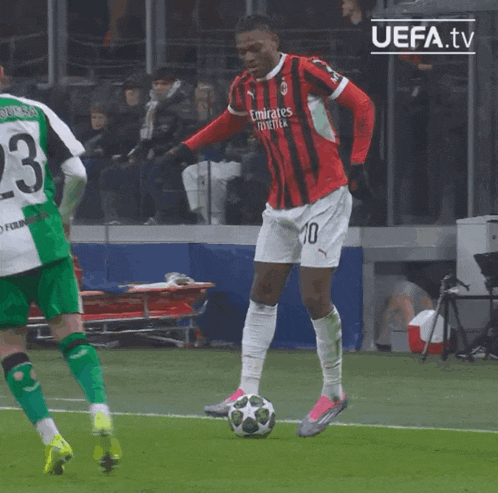 a soccer player wearing a red and black jersey with emirates written on it