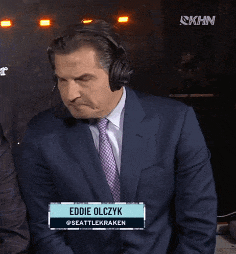 a man in a suit and tie is wearing headphones