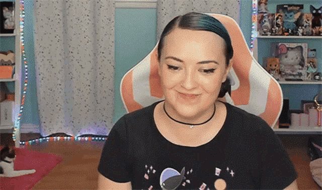 a woman with blue hair is sitting in an orange and white chair .