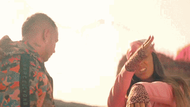 a man and a woman are standing next to each other in front of a mountain .