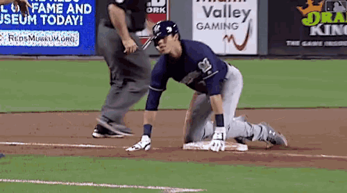 a baseball player is kneeling on the base in front of a valley gaming sign