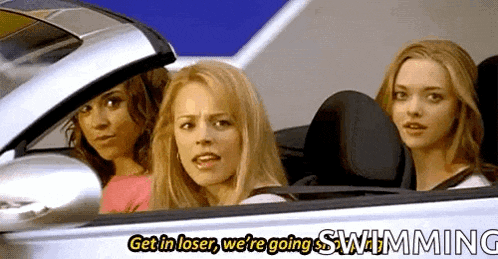 three women are sitting in a car with the words `` get in loser , we 're going swimming '' written on it .
