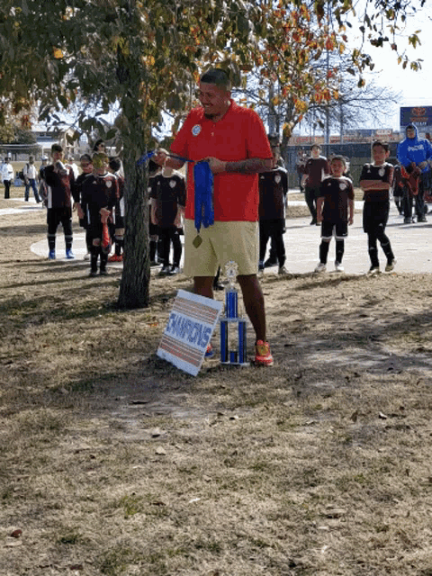 a man stands in front of a sign that says champions on it