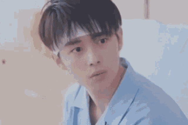 a young man wearing a bandage on his head is sitting in a hospital bed .