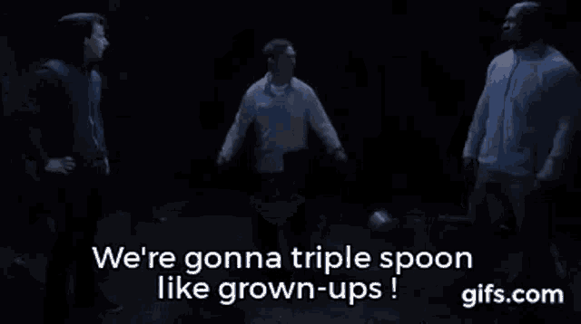 a group of men are standing next to each other in a dark room and talking about triple spoon like grown-ups .