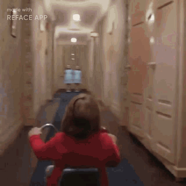 a little girl is riding a scooter down a hallway in a hallway .
