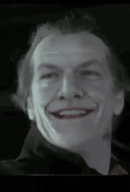 a close up of a man 's face with a joker smile .