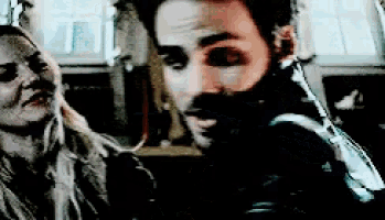 a man with a beard is looking at a woman .